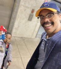 a man with glasses and a hat is holding a toy